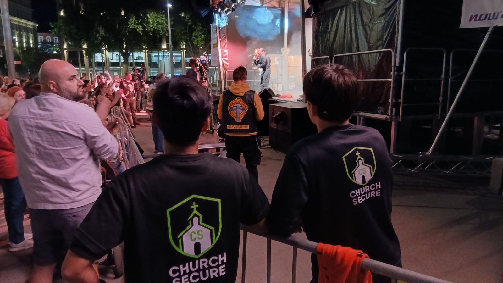 Zwei Teammitglieder in Church-Secure-Shirts sichern den Bühnenbereich bei einem Abendkonzert