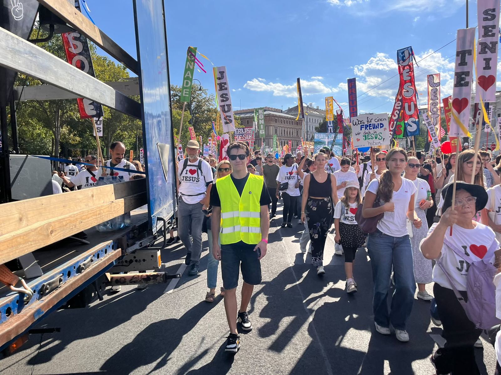 Ordner in Warnweste begleitet den Marsch für Jesus mit Jesus-Schildern