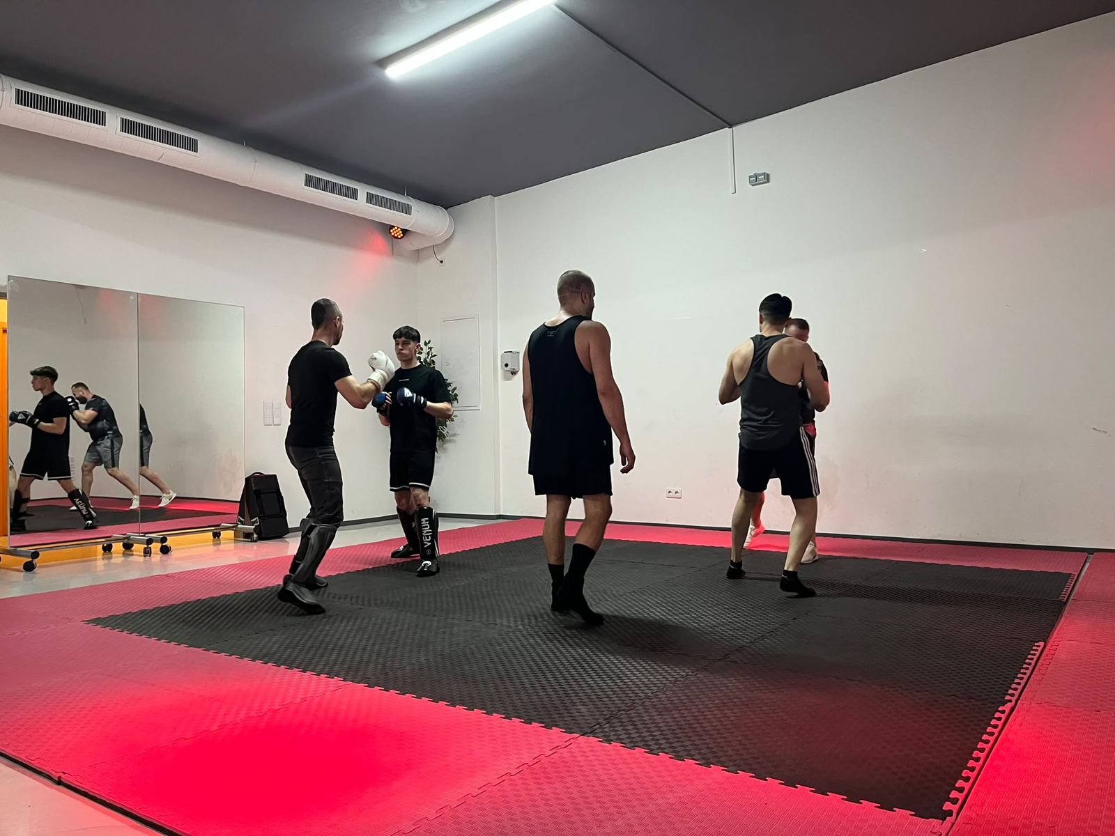 Partnerübung mit Schutzausrüstung auf der Trainingsmatte